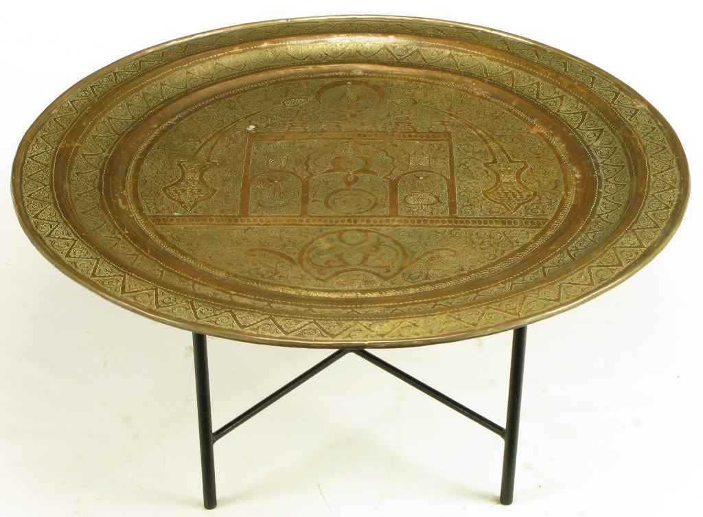 Vintage Moroccan etched brass large round tray on custom made black lacquered wrought iron stand with lower x stretcher. Would make a striking coffee table for a Moroccan style interior.