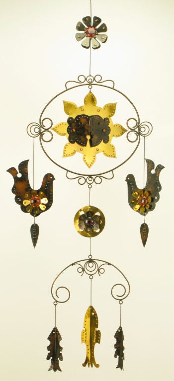 Cut and pierced brass and copper mobile, after Sergio Bustamante. Constructed with birds, fish, a flower and a sun face. Fixed with brass rods and brass filigreed hangers and adorned with ceramic  demilune ornamentation.