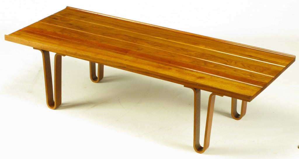 Plank wood bench, with gallery sides, styled after the long john bench by Edward Wormley for Dunbar. Bent plywood hair pin legs and walnut wood construction, incised lines to resemble grooved planks. Would also make a great coffee table.