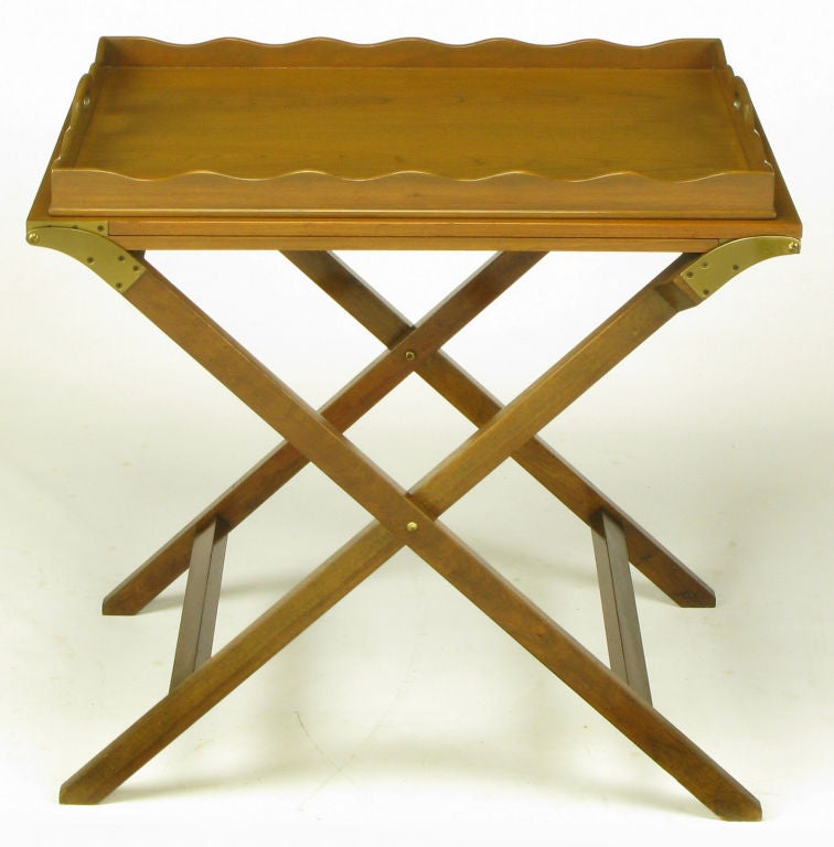 Butler tray table, with folding X-base, in original light walnut finish from Baker Furniture. Two flush panel mahogany butterfly leaves unfold from the center on heavy brass hinges to create a 92