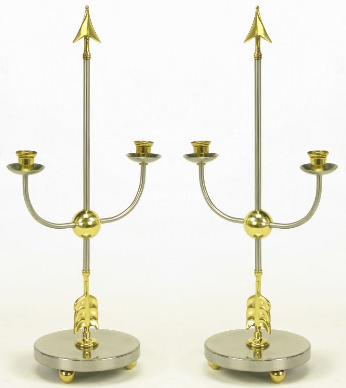 Pair of Italian empire style candelabra with center arrows and  u shaped candle holders all intersecting a brass ball. Surmounted on a brushed steel base with brass ball feet, signed.