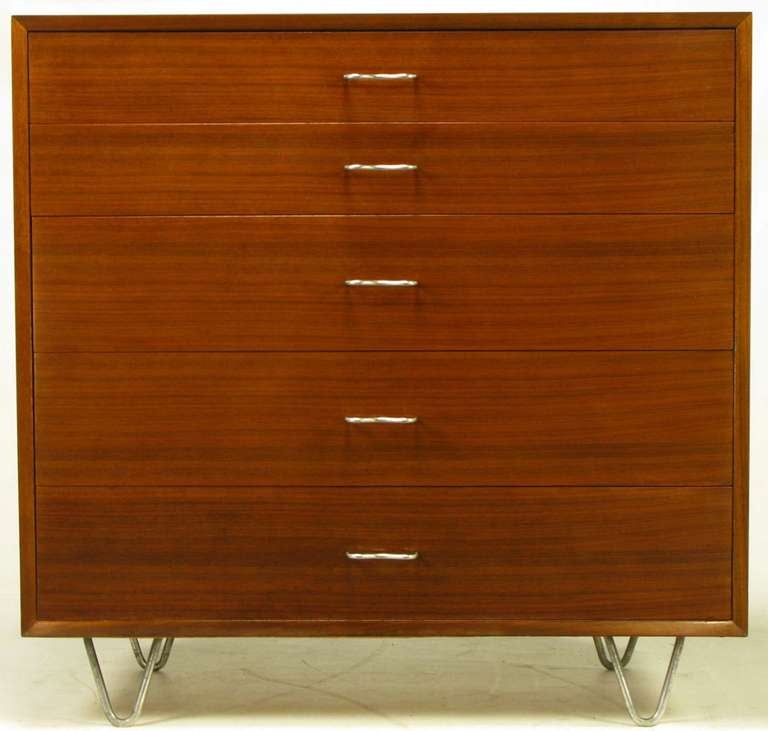 Ribbon mahogany five-drawer dresser by George Nelson for Herman Miller. M-shaped aluminum pulls and hair pin aluminum legs. Top drawer is partitioned as is the third deeper drawer.