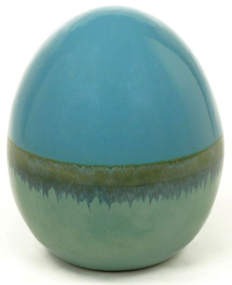Fourteen inches tall by twelve inches diameter hand thrown pottery egg with cadet blue and seafoam green glaze with a drip glaze banding.
