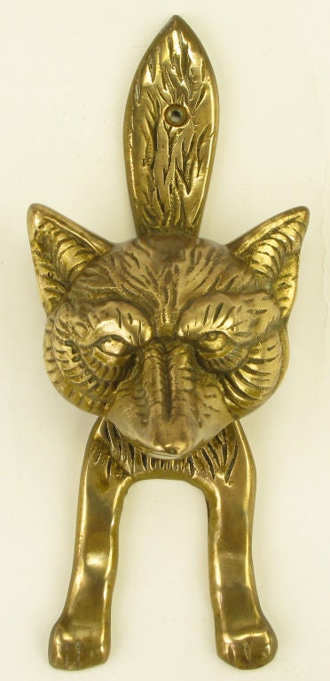 Clever door knocker in the form of a fox mount. The head is the knocker and the body is the strike plate. Hinged where the back of the head meet the base of the tail. Constructed of solid cast brass.