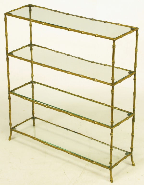 Small footed etagere in solid brass bamboo design. Four sections with glass shelves. Similar to designs from lauded French design house, Maison Bagues.  Most likely of Italian origin.<br />
<br />
8.5