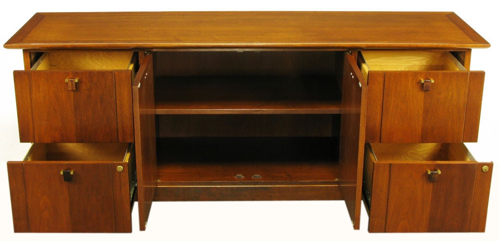 Edward Wormley for Dunbar mahogany cabinet with four large drawers and a center shelved cabinet on plinth base. The pair of cabinet doors and drawers are accessed by carved solid rosewood drop pulls that are mounted with solid brass squares and