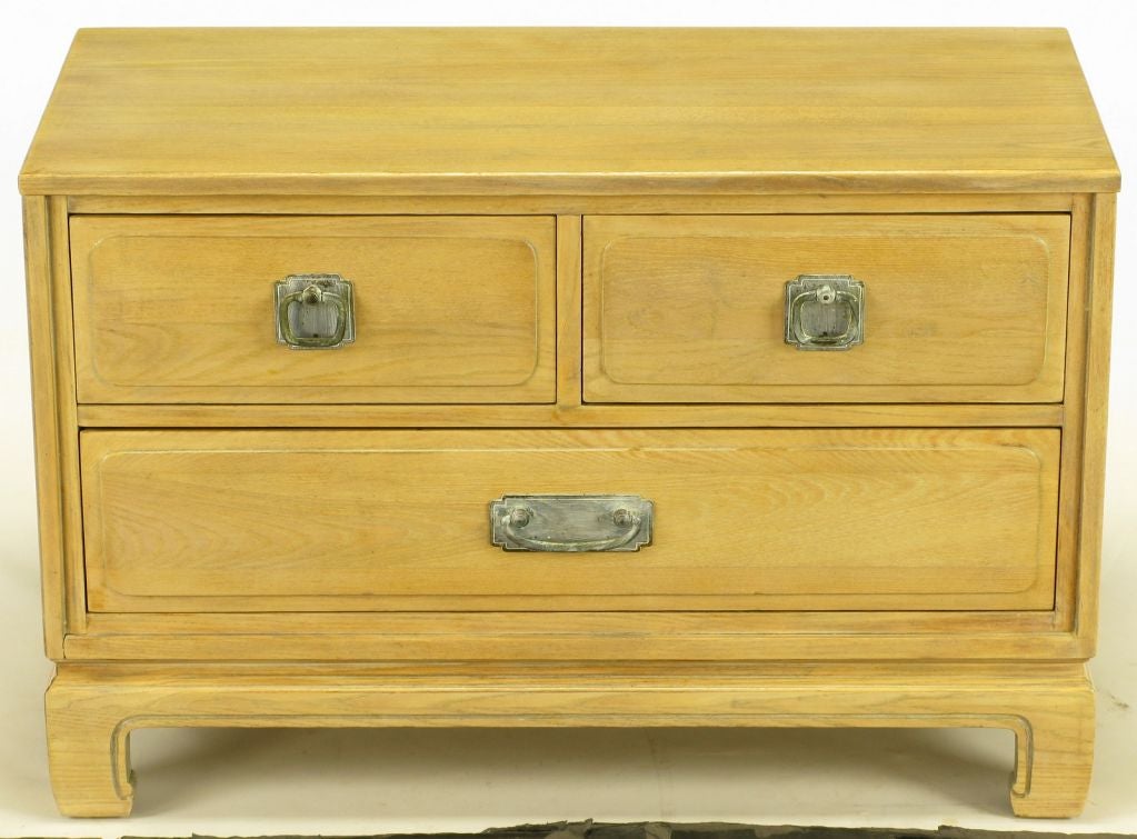 Petite three drawer bleached and glazed walnut commode. Ming style legs with recessed border. Drawers have projected radius corner carved panels with white glazed brass pulls and escutcheons. Manufactured by Nashville Tennessee family run Davis
