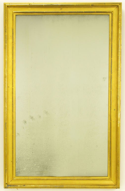 Very well aged parcel gilt and ochre lacquered mirror. Aged silver backing shows dark crazing and signs of stress that creates a wonderful patina.