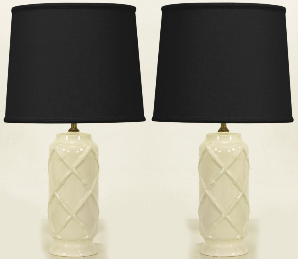 White glazed all ceramic table lamps with woven bamboo relief. Brass spacer with brass harp and socket. Sold sans shades.