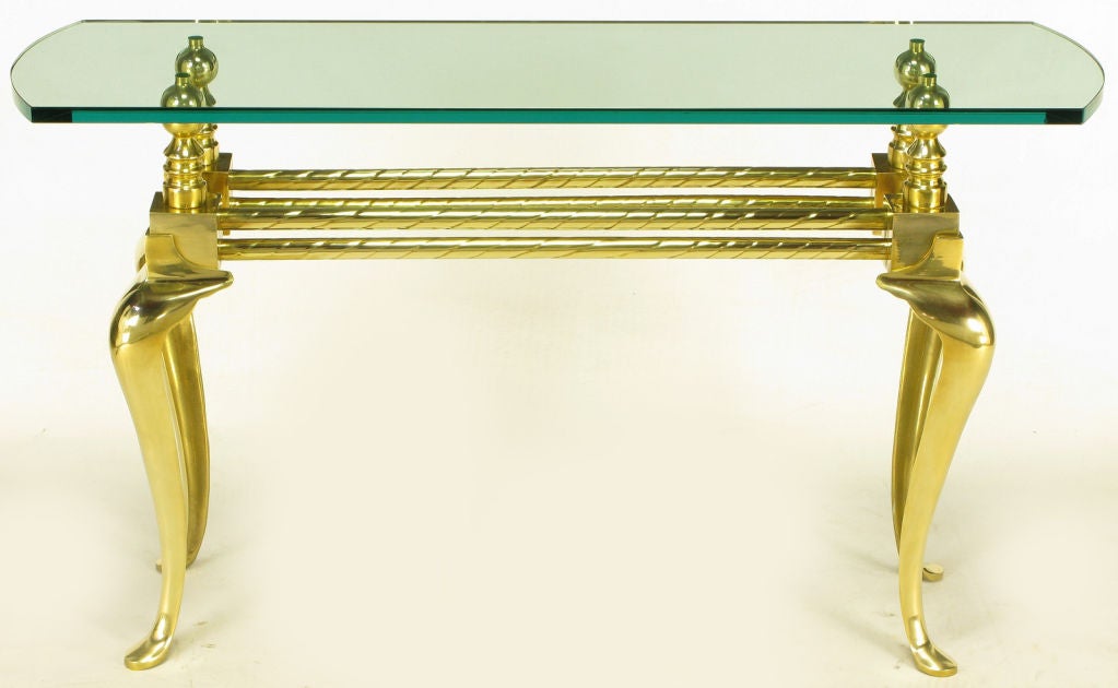 Cast and polished brass cabriole leg glass top console table. Twisted brass tube double stretcher connects brass cubes and large ball end finial risers. Three quarter inch thick glass top with radius ends and polished edge.