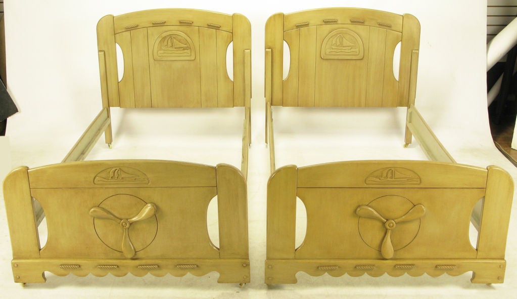 Wonderfully designed and executed twin beds with hand carved wood sail boats, propellers and sections of rope. Foot boards have wave like carved lower openings. Lacquer has aged to a light sage color, perfect for a nautical themed guest room or boys