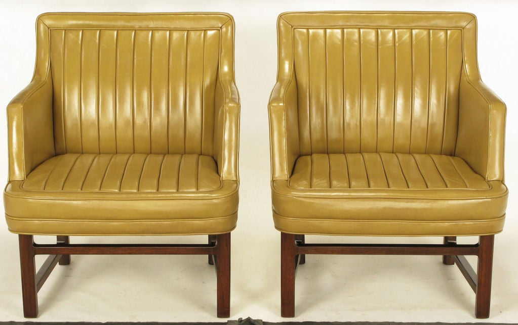 Pair of Edward Wormley for Dunbar taupe leather and mahogany arm chairs. Original channeled leather seats and backs with mahogany legs and stretchers. Rare design from Wormley and Dunbar.
