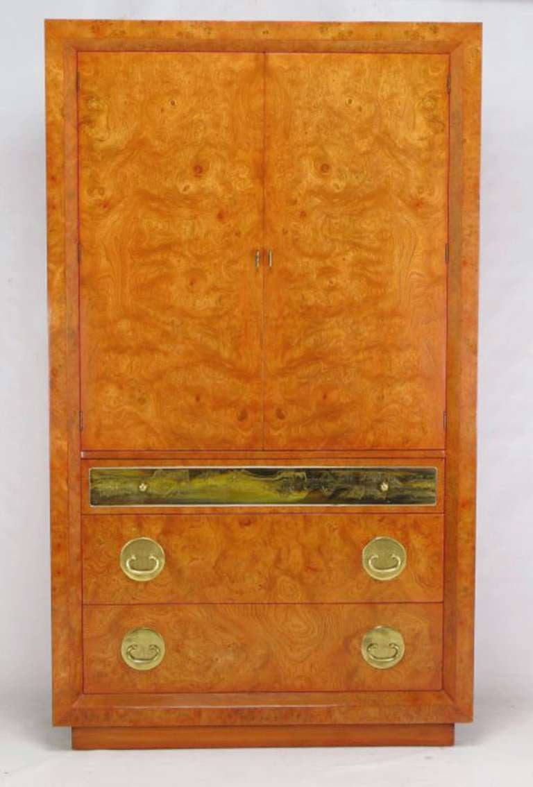 An unusual and rare Mastercraft tangerine stained tall wardrobe cabinet, or armoire. Three drawers in the base with th4 top drawer having an acid etched panel by Bernhard Rohne. The upper compartment is fronted by two doors, and offers storage in