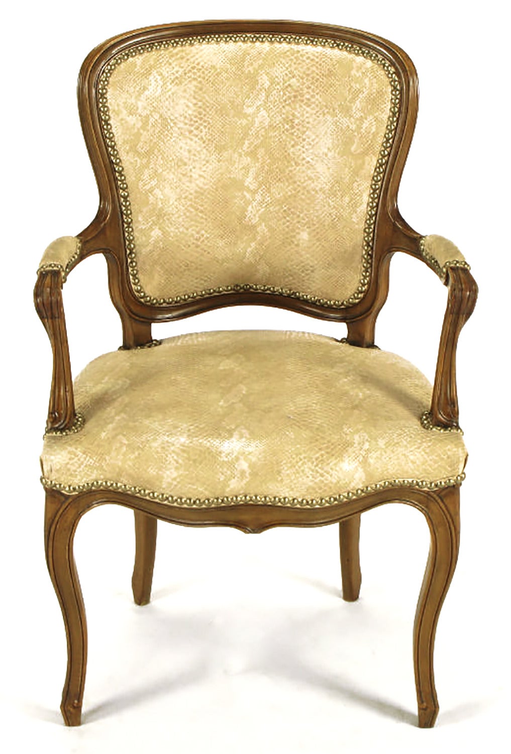 Pair of heavily carved Louis XV style armchairs on walnut frames with ivory and taupe simulated snakeskin upholstery with brass nail head detailing.