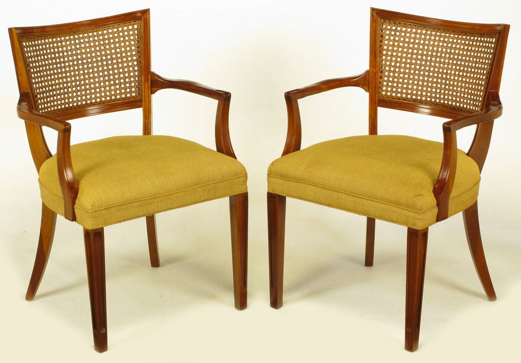 Pair of caved mahogany regency arm chairs with curved cane backs and silk/linen upholstered seats. Scalloped arms and curved risers, recessed carved panel front legs with saber back legs.<br />
Manufactured by the highly regarded Michigan quality