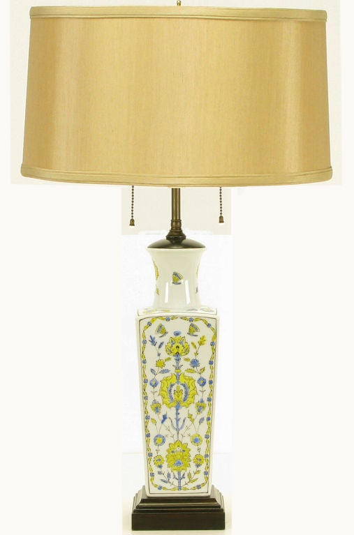 Asian ceramic vase form table lamp with hand painted cornflower blue and saffron foliate detailing over white glaze. Beveled and ebonized wood base with wood cap. Brass stem with double socket cluster and brass riser. Sold sans shade.