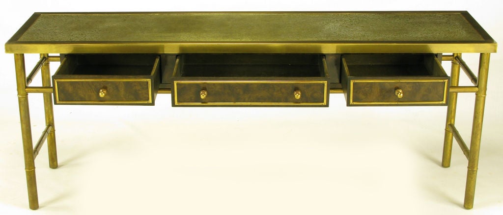 Early embroidered label, brass and burl amboyna wood three drawer casement long console by Mastercraft. Stylized bamboo doweled frame with floating three drawer casement section under a textured and patinated brass top. Each drawer has a brass