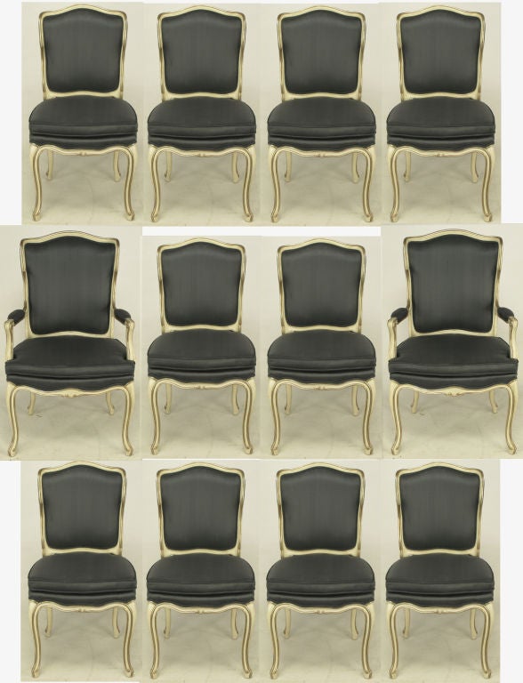 Set of twelve Richard Wheelwright Inc. fresh charcoal silk upholstered dining chairs. Ivory glazed cabriole leg hardwood frames with parcel silver leaf detail. Slight return to the top seat back giving the two arm chairs as well as the ten side