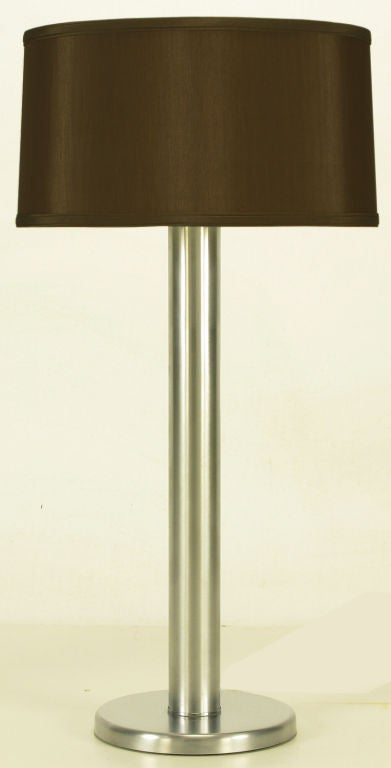 Brushed steel cylinder table lamp with brushed steel base. Double socket illumination with top side three way switch. Attributed to Walter Von Nessen Lighting, NY. Diameter measurement is of the base; cylinder is 2