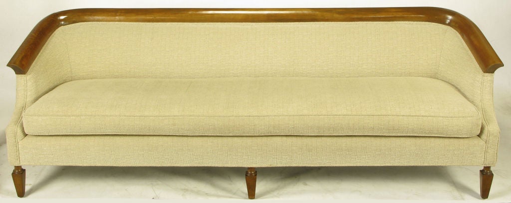 Elegant empire revival, long seat cushion sofa clad in a textured taupe chenille upholstery.  Walnut rolled edge and sloped arm and back top detail. Walnut reverse obelisk style legs. Possibly a Baker or Henredon design, excellent build quality.