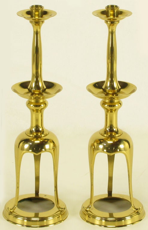 Pair of tall solid brass open tripodal base candle sticks. Double, graduated bobeches and top spikes that can be used as pricket, or can be inverted to use standard candle sticks.