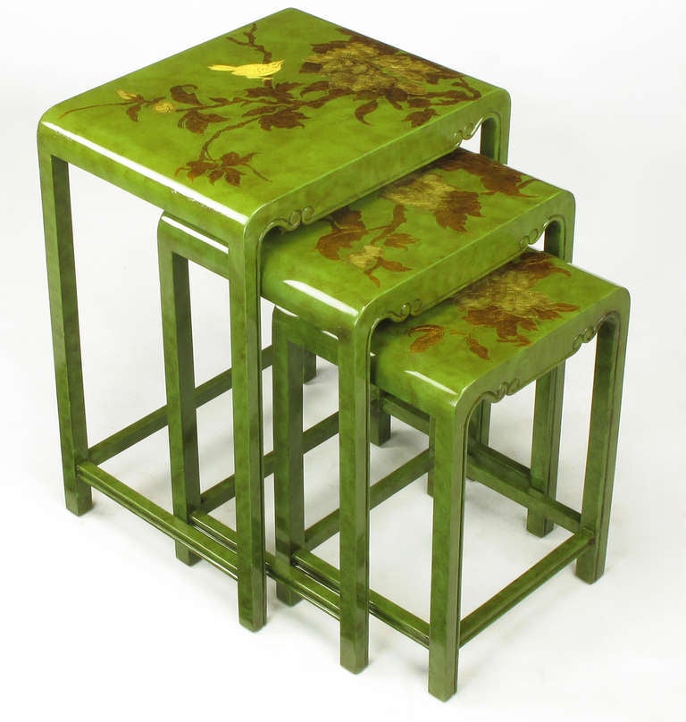 Set of three nesting tables in rich jade green lacquer with an umber glaze. Each table top has a flora and fauna gilt and lacquered embossing with contrasting line detail.