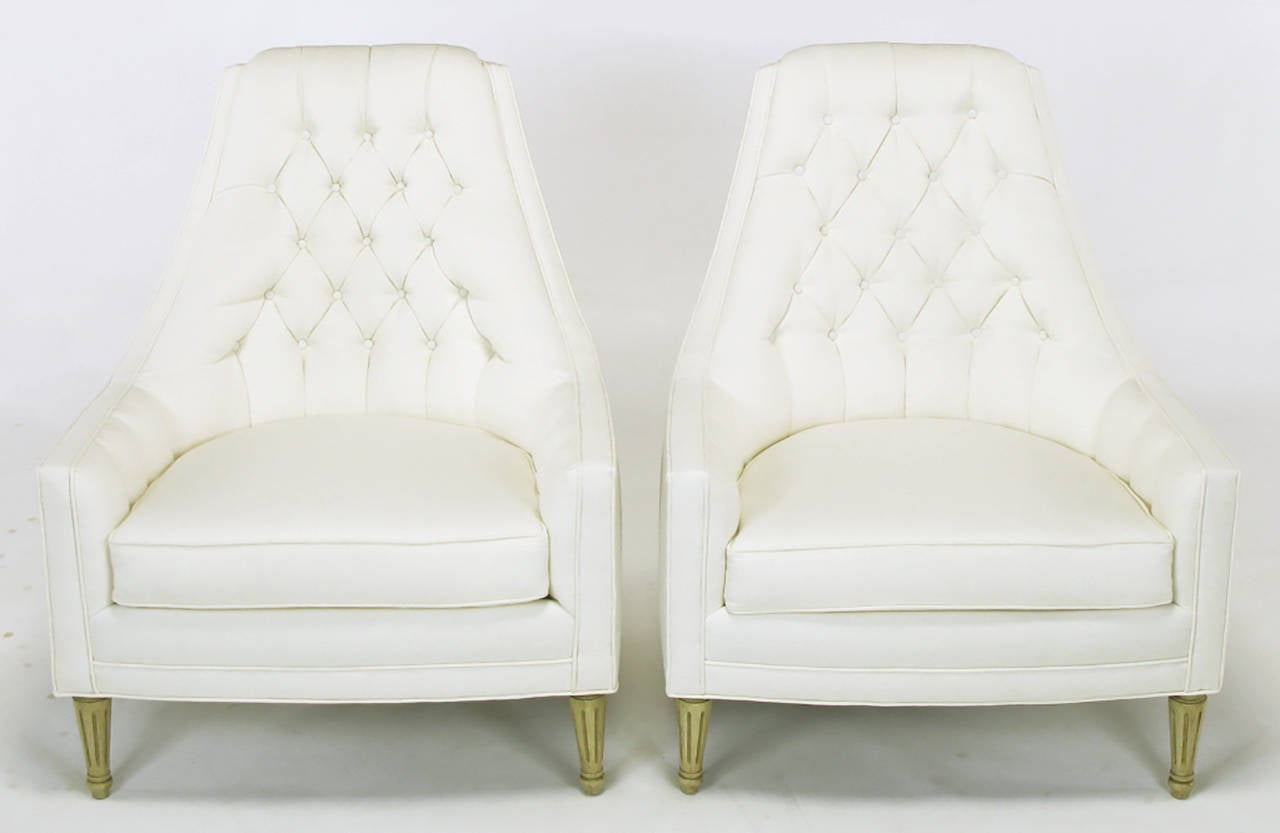 Sculptural and exquisitely designed lounge chairs in a new heavy white linen upholstery. The front legs are fluted and finished, as are the back legs, in an aged ivory lacquer.