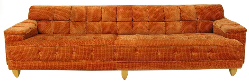 Early Dunbar, according to the nonagenarian original owner, circa 1940s long sofa. Nine feet in length, with large button detailing to the front and seat. Deep square channeled back and arms. Curved inverted obelisk style bleached mahogany triple