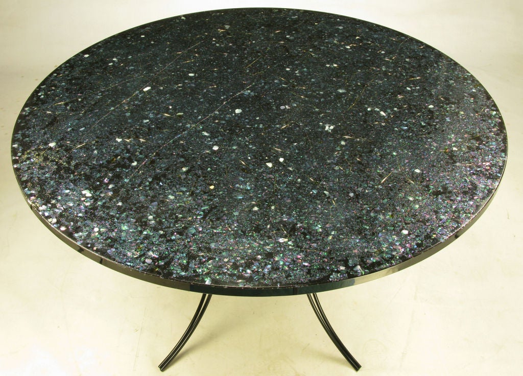 Exceptional round top dining table with satin black wrought iron saber leg base. Black resin with abalone shells, gold and silver flakes and clear resin makes for a colorful petite dining table.
