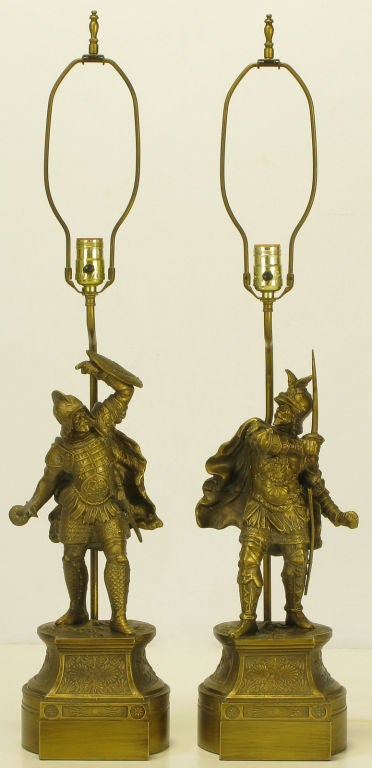 Unexpected pair of cast brass statuettes in the form of Spanish Conquistadors on brass pedestals. Animated form statuettes with swords, shields and flowing capes. Sold sans shades.