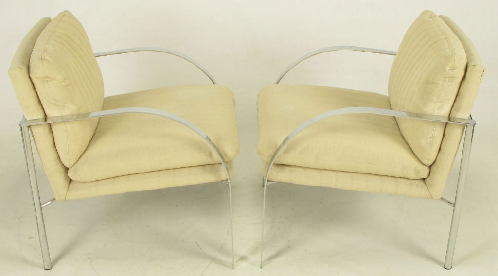 Two arm or club chairs, similar to Tuttle's Arco chairs, with natural Haitian cotton upholstery supported by sculptural chrome frames.