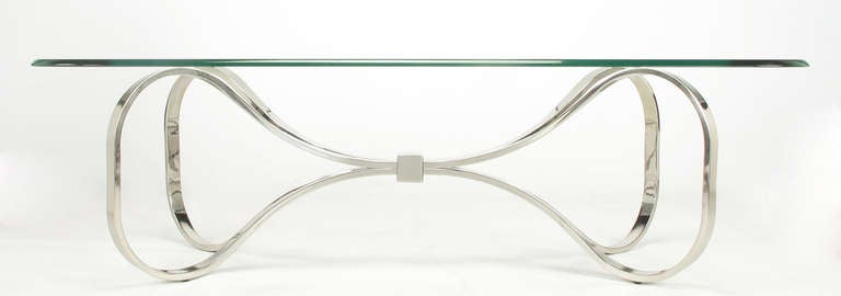 Chromed and hollow flat bar steel ribbon coffee table. Each piece comes together in the center, as a bow would, and are wrapped with a square chrome piece. Half inch cast glass top in the shape of a bow.

For best price and shipping options,