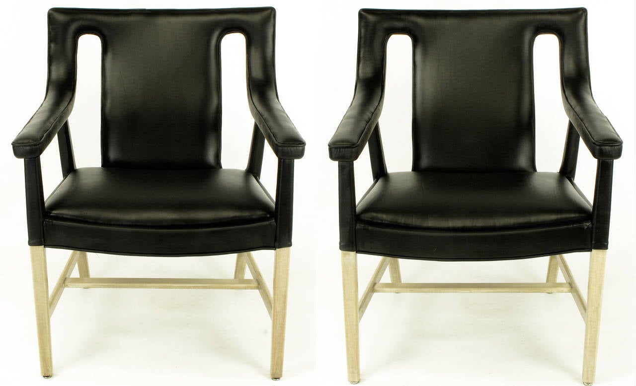 Rarely seen pair of John Widdicomb lounge chairs with single piece bentwood back and arms. Elliptical seat with bleached and glazed mahogany legs and stretchers. The new Spinnevbeck black leather wraps all surfaces expect 2/3 of the legs and