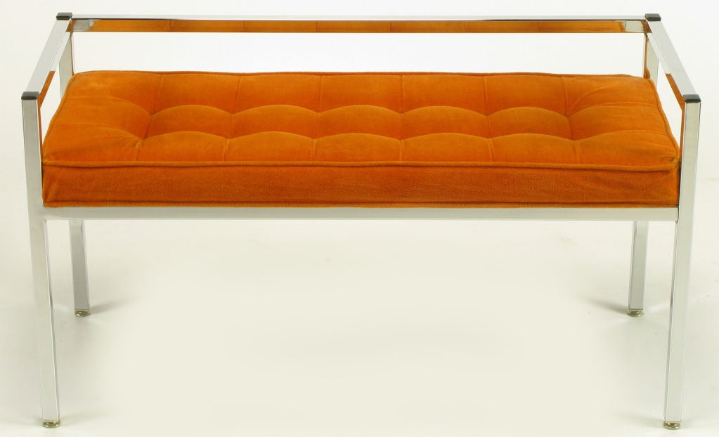 Chromed metal square bar bench with open even half arms and back. Black cap corner details and button tufted tangerine velvet upholstery. Pair available, similar to designs by Knoll.