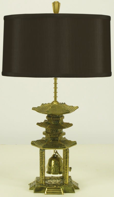 Multitiered pagoda style cast brass table lamp with center bell and Chinese characters. Uncommon and inspired table lamp, sold sans shade.
