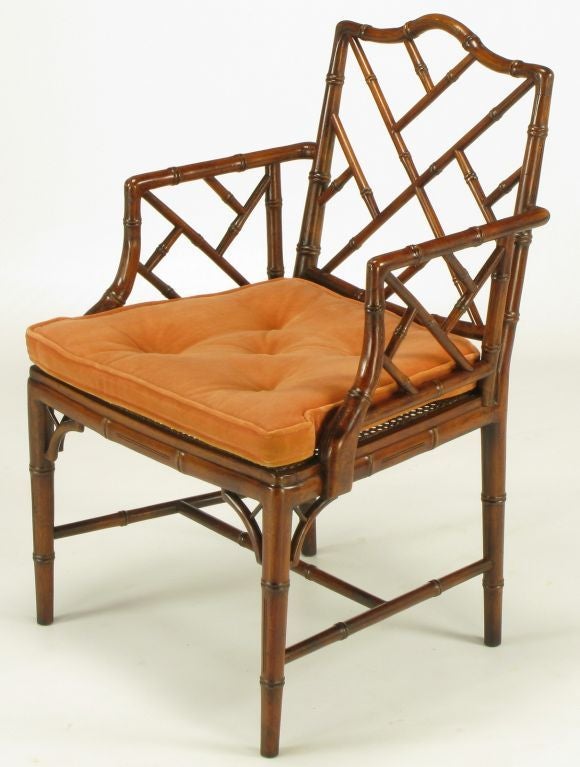 Carved mahogany Chinese Chippendale arm chair or desk chair by Hekman Furniture. Faux bamboo detailing and cane seat beneath a button tufted persimmon velvet box seat cushion. Open font corner brackets and H stretcher.