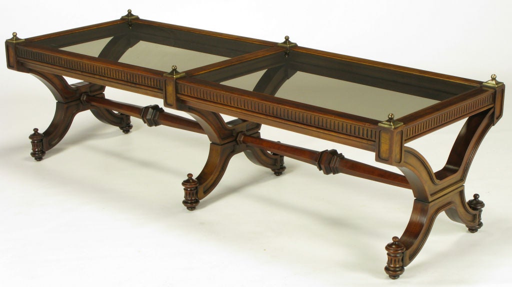 Empire revival coffee table in mahogany wood with curved X-form legs, and substantial hexagonal carved center stretchers. Recessed carved panels on the interior and exterior of the legs. Finial topped feet are fluted half round columns. Fluted apron