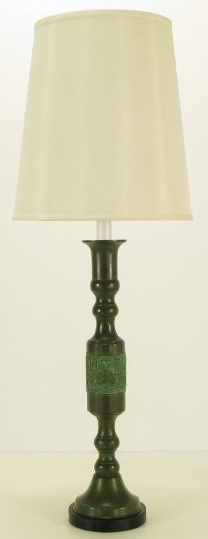 Almost four feet tall segmented and  patinated bronze table lamp with center relief band of Greek key and Asian character details. Round black lacquered plinth base and finial. White lacquered brass stem with brass socket and harp. Sold sans shade.