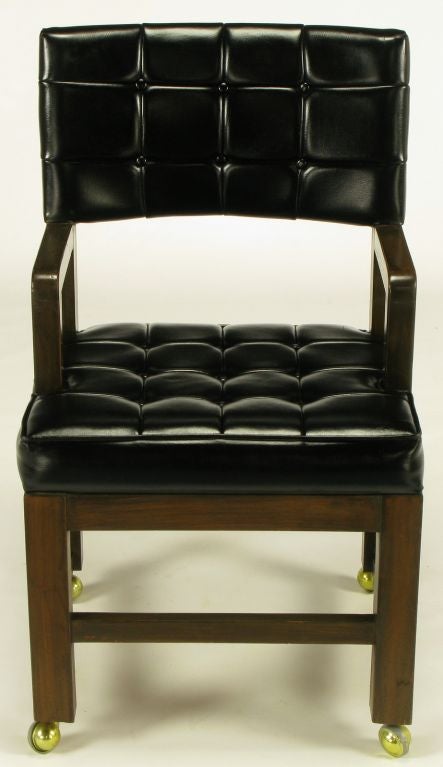 Mahogany framed desk chair with black vinyl button tufted seat and back. Deep set arms allow the chair to be situated closer to the desk. Brass casters are removable.