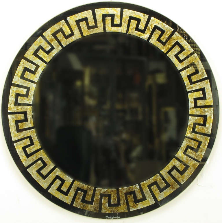 Round David Marshall signed mirror with reverse gilt Greek key detail. Each segment of the Greek key design is reverse gilt with gold ,silver, and copper leaf. Mounted on a round wood backing.

