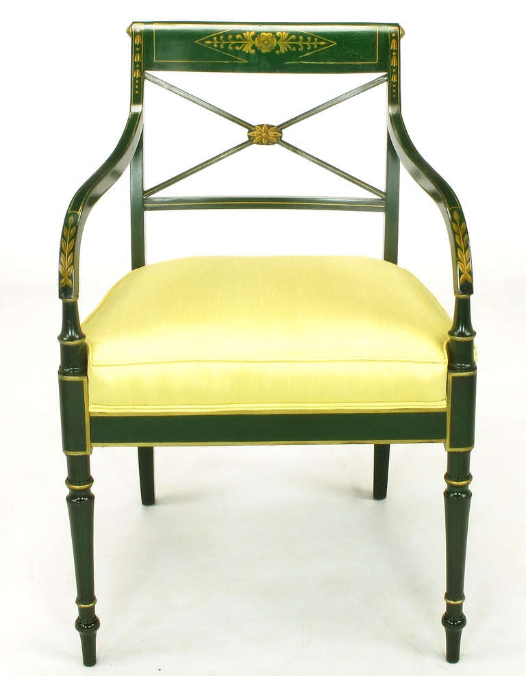 Emerald green lacquered arm chair with silk upholstered seat and gilt detailing. Sloping arms begin at the spindle style legs and finish at the crossed back with hand painted gilt center rosette. Seat is upholstered in butter yellow silk. Attributed