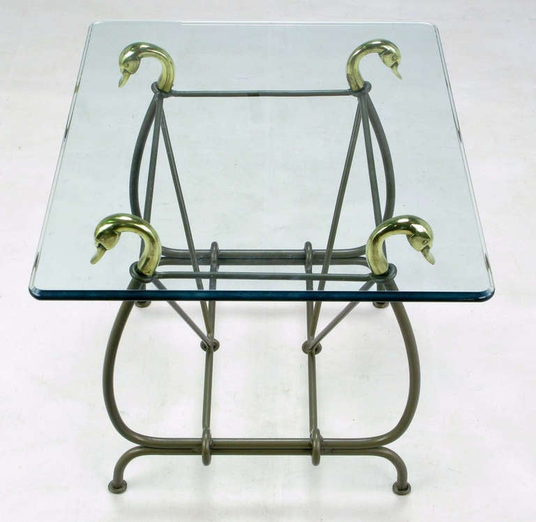Wrought iron side table with cast brass swan heads as glass supports and lacquered in gun metal grey. Lyre-form frame is comprised of stylized swan necks, footed and curved legs with V shaped stretchers. Ogee beveled edge glass top is one half inch