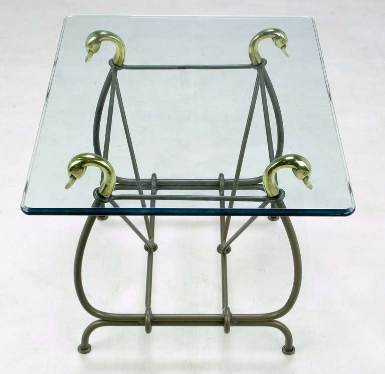 Beistelltisch aus Schmiedeeisen mit Schwanenköpfen aus Messingguss als Glasträger und in gun metal grey lackiert. Der Rahmen in Form einer Leier besteht aus stilisierten Schwanenhälsen und geschwungenen Beinen mit V-förmigen Trägern. Ogee