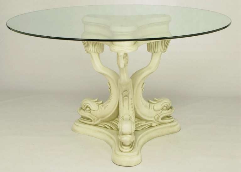 Impressive trio of dolphins made of heavy cast gesso and resin, with an antiqued ivory lacquer finish. French inspired piece would work well as a center table as well as an intimate dining table. Round glass top is 1/2