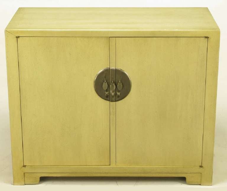 Pair of Baker Asian inspired two door cabinets, from Winsor White's Far East Collection. One cabinet features three drawers and the other has open shelf storage. Large round nickel escutcheons and drop disc pulls are exceptional. Bases feature