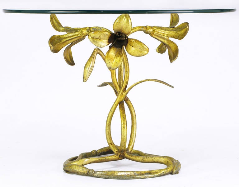 From Drexel's Et Cetera Collection, an Art Nouveau and Arthur Court inspired cast aluminum side table, with an aged gilt finish. Base is comprised of three flowering lilies with intertwined stems in a figure eight pattern, finishing with a circular