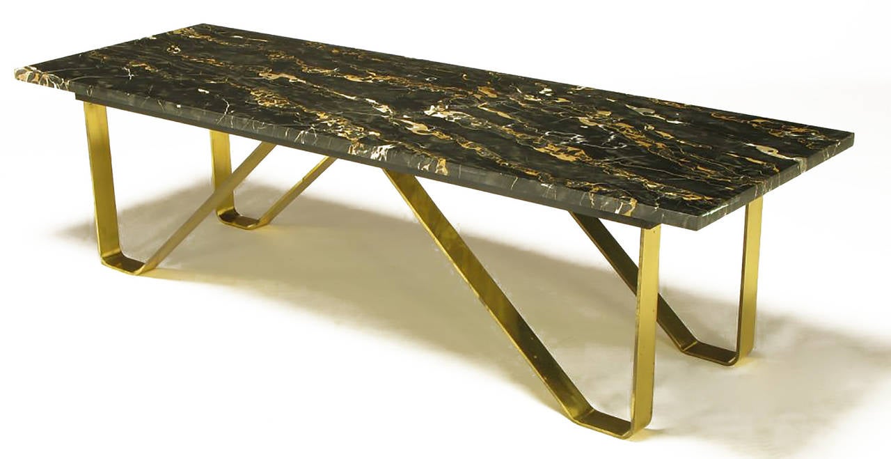 Custom designed coffee table comprised of rectangular black Italian portoro marble top, and solid brass flat bar hair pin style legs. Beautiful Italian portoro marble is black with white and umber veining. No longer being mined with this type of