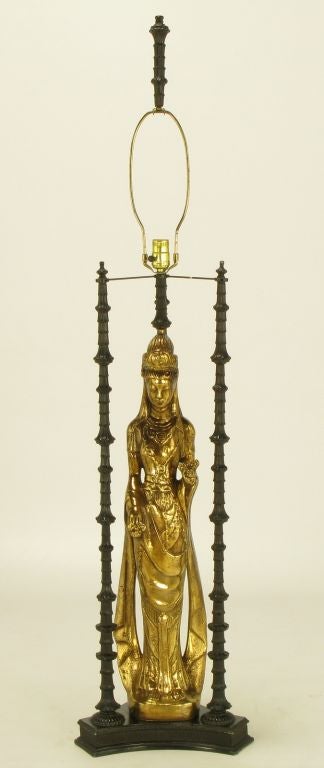 In the manner of James Mont or Tony Duquette, this fifty five inch tall lamp contains a d'ore bronze statue of Quan Yin a/k/a Kuan Yin a/k/a Guanyin, the Chinese goddess of mercy.  Lacquered metal three-column shrine surrounds her.   This Asian form