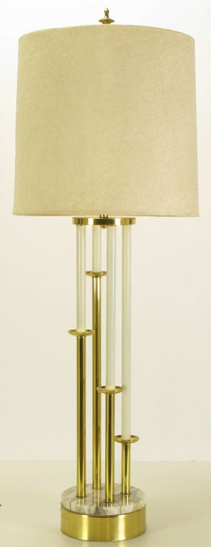Sculptural stepped brass candlesticks on a round Carrera marble and brass base. Ivory lacquered 