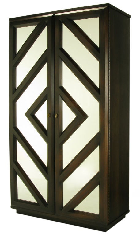 Tall dark finished wood and mirror geometric front two door dry bar. Mirrored and illuminated upper section and lower section with a single drawer and locking two-door cabinet with single shelf. Outstanding build quality and finish, and most likely